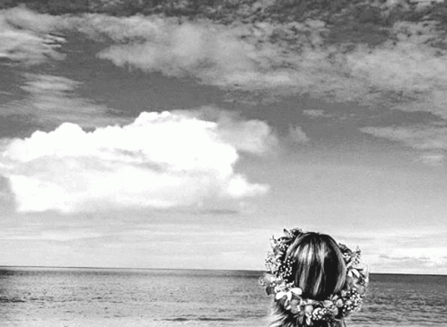 Black and White Woman Looking Over Ocean With Flower Crown