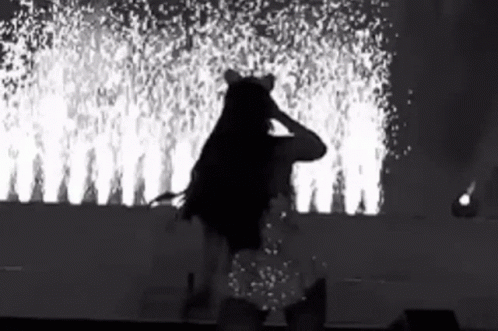 Black And White Woman On Stage With Fireworks GIF