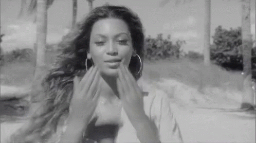 Black and White Woman With Hoop Earrings Touching Face