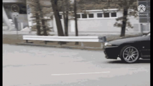 Black Car Driving Past White Fence GIF
