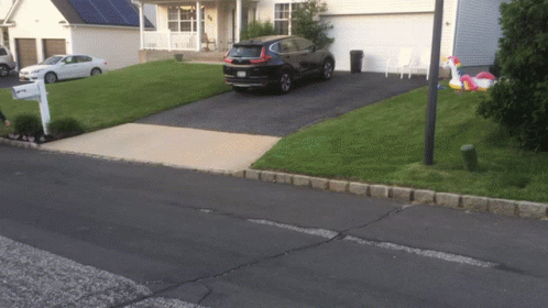 Black Car in Front of White House With Mailbox Saying A