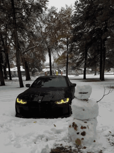 Black Car Parked in Snow With Snowman