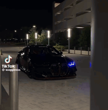 Black Car Parked Next to Tik Tok Sign