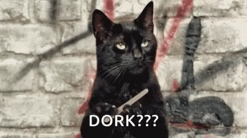 Black Cat Holding Scissors in Front of Brick Wall