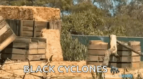 Black Cyclones Sign in Front of Hay Pile