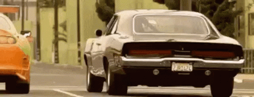 Black Dodge Charger Driving Beside Red Car