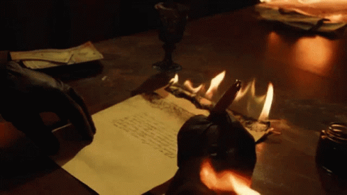 Black Hand Writing On Fire Burning Paper GIF
