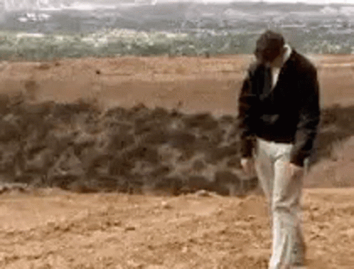 Black Jacket White Pants Man Standing In Desert GIF
