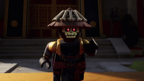 Black Lego Figure With Straw Hat In Front Of Building GIF