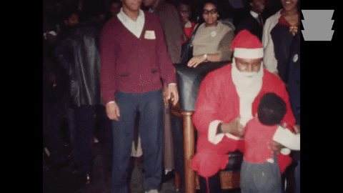Black Santa Letting Kid Sit On His Lap GIF