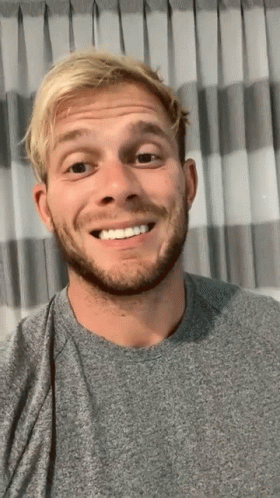 Blonde Haired Man With Beard Smiling In Front Of Curtain GIF