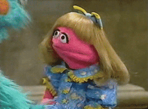 Blonde-Haired Pink Puppet in Blue Dress Next to Blue Puppet
