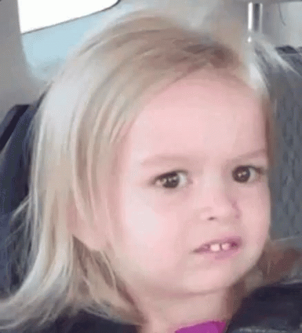 Blonde Little Girl Making Funny Face in Car Seat
