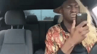 Blonde Man Looking At Phone In Back Seat