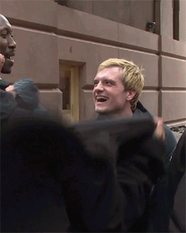 Blonde Man Smiling In Front Of Building Number 8 GIF