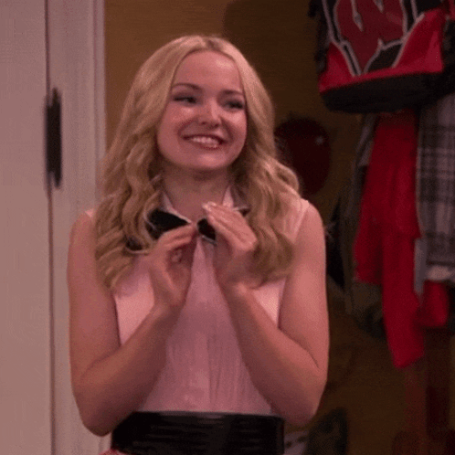 Blonde Woman In Bow Tie And Pink Shirt Smiles GIF