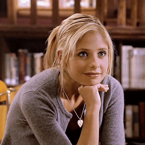 Blonde Woman in Grey Sweater and Heart Necklace