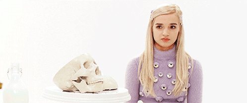Blonde Woman in Purple Sweater Next to Skull