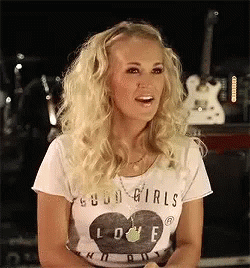 Blonde Woman in White Shirt Saying Good Girls Love