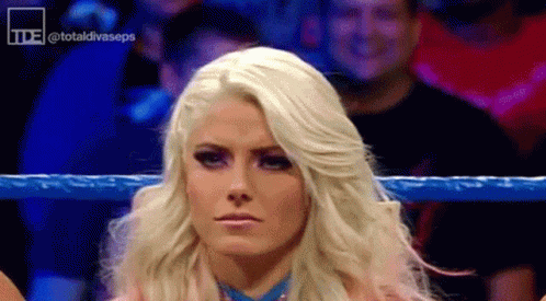 Blonde Woman Standing in Wrestling Ring With Crowd