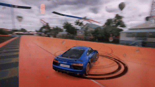 Blue Car Driving on Orange Track