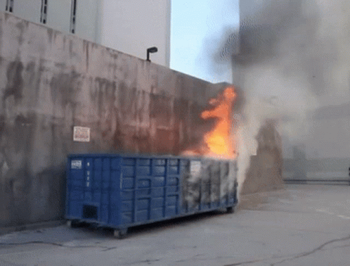 Blue Dumpster on Fire With No Parking Sign