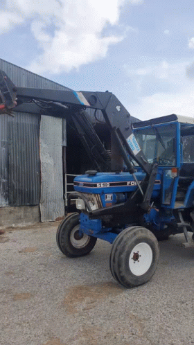 Blue Ford Tractor Parked Outside Building