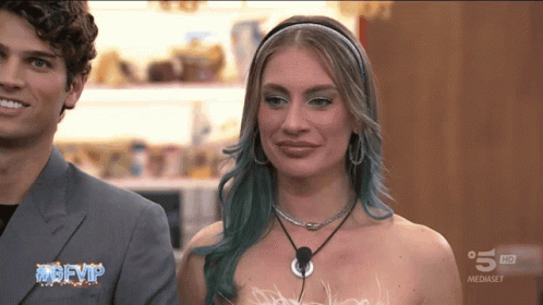Blue Hair Woman Next to Man TV Saying mgfvip