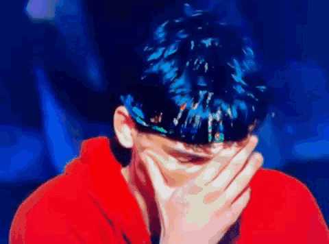 Blue-Haired Man Covering Face