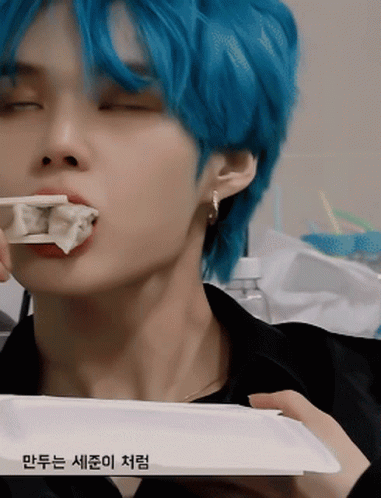 Blue-Haired Young Man Eating Dumplings With Chopsticks