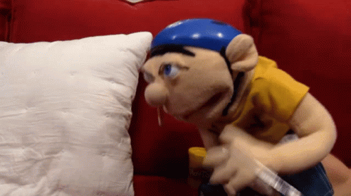 Blue Helmet Puppet on Red Couch With White Pillow