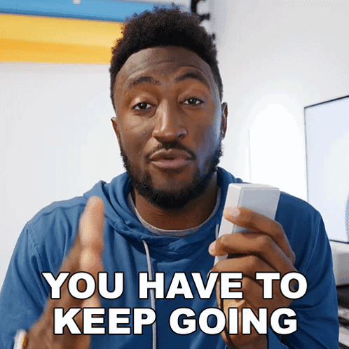 Blue Hoodie Man Holding Remote Control You Have to Keep Going