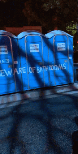 Blue Portable Toilets With Beware Of Bathrooms Written On Them GIF