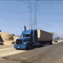 Blue Semi Truck Driving Down Highway Beside Dirt Field