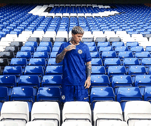 Blue Shirt Man at Stadium with Blue White Seats