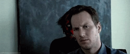 Blue Shirt Man Sitting In Front Of Demon Painting GIF