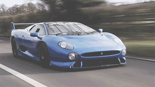 Blue Sports Car Driving Down Road With Trees GIF