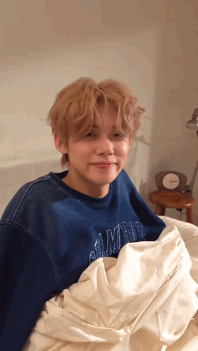 Blue Sweatshirt Young Man Laying on White Blanket