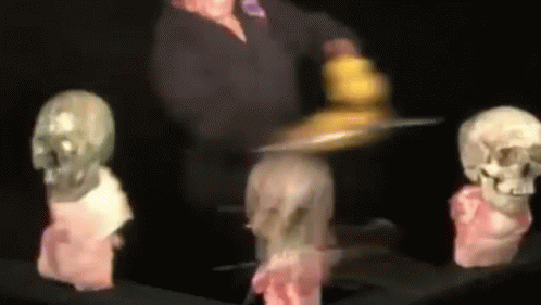 Blurred Person Holding Tray in Front of Skulls