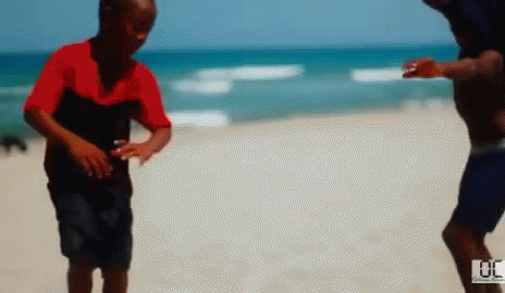 Blurry Man and Boy on Beach With Number 30