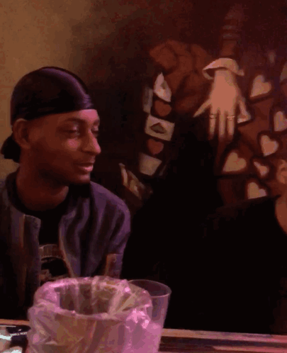 Blurry Man At Table With Bag Of Money GIF