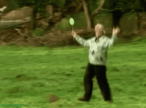 Blurry Man Holding Badminton Racket In Park GIF