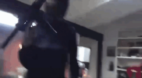 Blurry Man Holding Gun In Room GIF