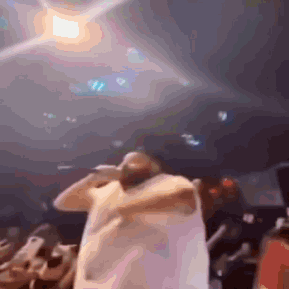 Blurry Man Holding Microphone in Front of Crowd