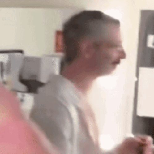 Blurry Man in Kitchen With Microwave