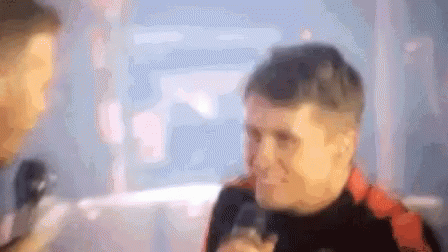 Blurry Man Talking Into Microphone With Onlooker GIF