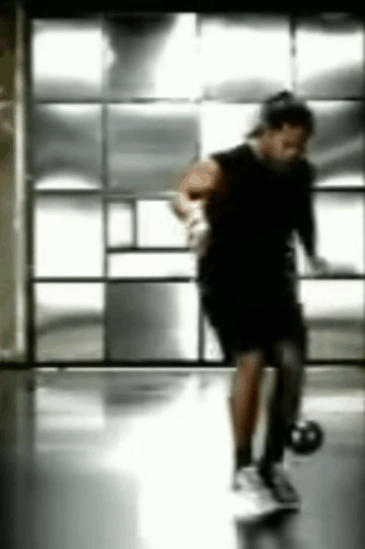 Blurry Person Holding Basketball in Gym