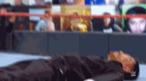 Blurry Person Laying on Ground with Wrestling Logo