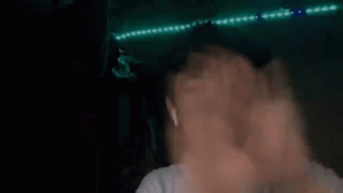 Blurry Person's Face and Hands With Green Lights