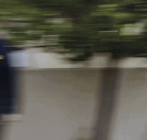 Blurry Person Walking Along Sidewalk
